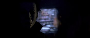 Movie still from “Halloween: Resurrection” (2002), directed by Rick Rosenthal – A man with dark hair is in front of a television; Close Up shot, Over the shoulder angle