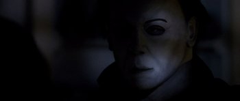 Movie still from “Halloween: Resurrection” (2002), directed by Rick Rosenthal – The face of a person in a dark room; Close Up shot, Low angle