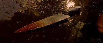 Movie still from “Halloween: Resurrection” (2002), directed by Rick Rosenthal – A knife that is laying in the water; Extreme Close Up shot, High angle