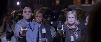 Movie still from “Halloween: Resurrection” (2002), directed by Rick Rosenthal – A group of people standing next to each other holding microphones; Medium shot, Over the shoulder angle