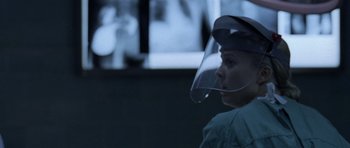 Movie still from “Halloween: Resurrection” (2002), directed by Rick Rosenthal – A woman wearing a face shield and a green shirt; Close Up shot, Over the shoulder angle