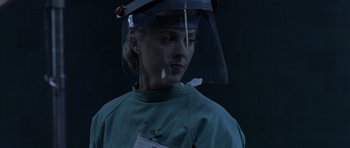 Movie still from “Halloween: Resurrection” (2002), directed by Rick Rosenthal – A woman wearing a surgical gown and a face shield; Close Up shot, Low angle