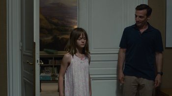 Movie still from “Happy End” (2017), directed by Michael Haneke – A little girl standing in front of a man in a room; Medium shot, Over the shoulder angle