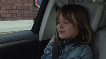 Movie still from “Happy End” (2017), directed by Michael Haneke – A little girl sitting in the back seat of a car; Close Up shot, High angle