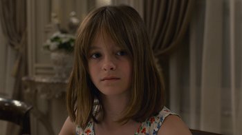 Movie still from “Happy End” (2017), directed by Michael Haneke – A young girl with long brown hair wearing a floral dress; Close Up shot, Over the shoulder angle