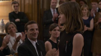 Movie still from “Happy End” (2017), directed by Michael Haneke – A man and a woman in front of an audience; Medium shot, Over the shoulder angle