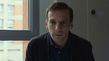 Movie still from “Happy End” (2017), directed by Michael Haneke – A person wearing a jacket; Close Up shot, High angle