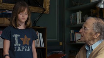 Movie still from “Happy End” (2017), directed by Michael Haneke – A girl and a man in a room with books; Medium shot, Over the shoulder angle