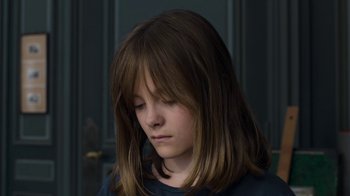 Movie still from “Happy End” (2017), directed by Michael Haneke – A young girl with long brown hair is looking down at her face; Close Up shot, High angle