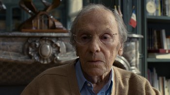 Movie still from “Happy End” (2017), directed by Michael Haneke – An old man wearing glasses sitting in front of a mirror; Close Up shot, Over the shoulder angle