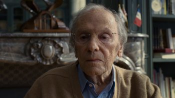 Movie still from “Happy End” (2017), directed by Michael Haneke – An old man wearing glasses sitting in front of a mirror; Close Up shot, Over the shoulder angle