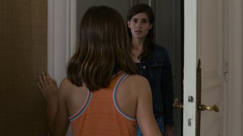 Movie still from “Happy End” (2017), directed by Michael Haneke – A woman standing in front of a mirror looking at another woman; Close Up shot, Over the shoulder angle