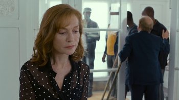 Movie still from “Happy End” (2017), directed by Michael Haneke – A woman in a polka dot shirt is looking down; Medium shot, Over the shoulder angle