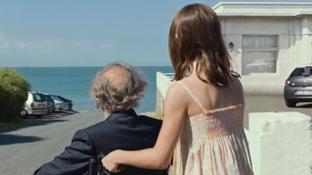 Movie still from “Happy End” (2017), directed by Michael Haneke – An old man and a young girl are looking out at the ocean; Medium shot, Over the shoulder angle