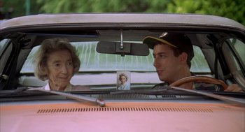 Movie still from “Happy Gilmore” (1996), directed by Dennis Dugan – A man and a woman sitting in the back of a car; Medium shot, Over the shoulder angle