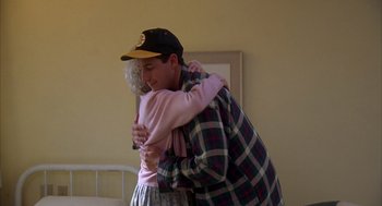 Movie still from “Happy Gilmore” (1996), directed by Dennis Dugan – An older man hugging an older woman in a bedroom; Medium shot, Low angle