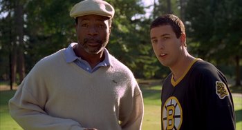 Movie still from “Happy Gilmore” (1996), directed by Dennis Dugan – Two men standing next to each other on a field; Medium shot, Over the shoulder angle
