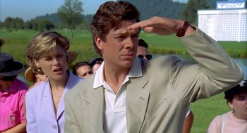 Movie still from “Happy Gilmore” (1996), directed by Dennis Dugan – Man saluting in front of a group of people in a field; Close Up shot, Low angle