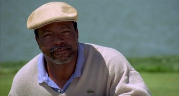 Movie still from “Happy Gilmore” (1996), directed by Dennis Dugan – A person wearing a hat near a body of water; Close Up shot, Low angle