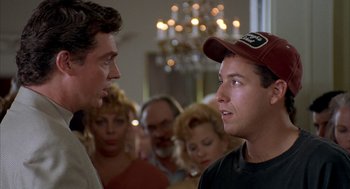 Movie still from “Happy Gilmore” (1996), directed by Dennis Dugan – Two men are talking to each other in front of a group of people; Close Up shot, Over the shoulder angle