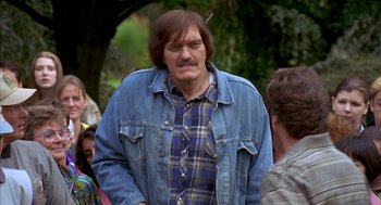 Movie still from “Happy Gilmore” (1996), directed by Dennis Dugan – A man with a beard and a blue jean jacket; Medium shot, Over the shoulder angle