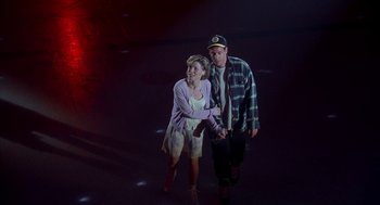 Movie still from “Happy Gilmore” (1996), directed by Dennis Dugan – A man and a woman are walking together; Wide shot, Low angle