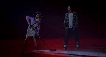Movie still from “Happy Gilmore” (1996), directed by Dennis Dugan – A woman and a man are playing hockey on a rink; Wide shot, High angle