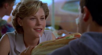 Movie still from “Happy Gilmore” (1996), directed by Dennis Dugan – A person sitting at a table with a sandwich; Close Up shot, Over the shoulder angle