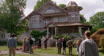 Movie still from “Happy Gilmore” (1996), directed by Dennis Dugan – A group of people standing in front of a large house; Extreme Wide shot, High angle