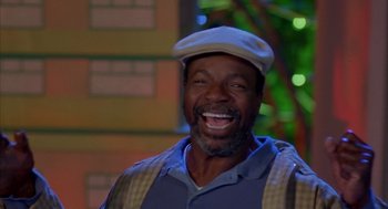Movie still from “Happy Gilmore” (1996), directed by Dennis Dugan – A man wearing a hat and smiling for the camera; Close Up shot, Low angle