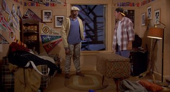 Movie still from “Happy Gilmore” (1996), directed by Dennis Dugan – Two men standing in a living room next to each other; Wide shot, High angle