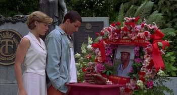 Movie still from “Happy Gilmore” (1996), directed by Dennis Dugan – A man and a woman standing next to a table with flowers; Medium shot, Over the shoulder angle