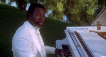 Movie still from “Happy Gilmore” (1996), directed by Dennis Dugan – A man in a white suit playing a white piano; Medium shot, High angle