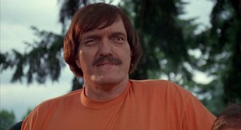 Movie still from “Happy Gilmore” (1996), directed by Dennis Dugan – A person wearing an orange t - shirt; Close Up shot, Low angle