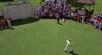 Movie still from “Happy Gilmore” (1996), directed by Dennis Dugan – A crowd of people watching a man in a baseball uniform swing a bat; Extreme Wide shot, High angle