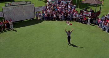 Movie still from “Happy Gilmore” (1996), directed by Dennis Dugan – A crowd of people are watching a man play golf; Extreme Wide shot, Overhead angle