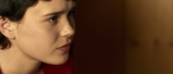Movie still from “Hard Candy” (2005), directed by David Slade – A woman's face in a dark room; Extreme Close Up shot, Over the shoulder angle