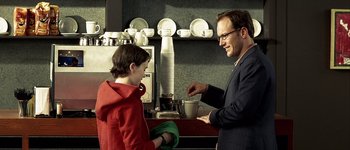 Movie still from “Hard Candy” (2005), directed by David Slade – A man and a boy in front of a coffee maker; Medium shot, Over the shoulder angle
