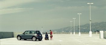 Movie still from “Hard Candy” (2005), directed by David Slade – A man and a woman standing in a parking lot next to a car; Extreme Wide shot, High angle