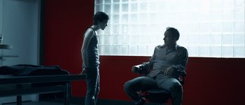 Movie still from “Hard Candy” (2005), directed by David Slade – A man sitting on a chair next to another man; Medium shot, Over the shoulder angle