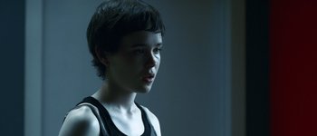 Movie still from “Hard Candy” (2005), directed by David Slade – A woman with short black hair wearing a black tank top; Close Up shot, Over the shoulder angle