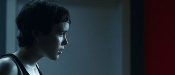 Movie still from “Hard Candy” (2005), directed by David Slade – A young child looking into the distance with a dark background; Close Up shot, Over the shoulder angle