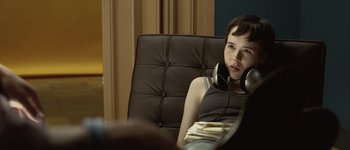 Movie still from “Hard Candy” (2005), directed by David Slade – A young boy sitting in a chair wearing headphones; Close Up shot, Over the shoulder angle