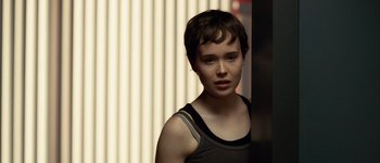 Movie still from “Hard Candy” (2005), directed by David Slade – A woman with short brown hair wearing a black tank top; Close Up shot, Over the shoulder angle