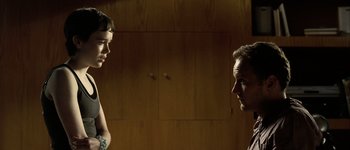 Movie still from “Hard Candy” (2005), directed by David Slade – A man and a woman standing next to each other in a room; Medium shot, Over the shoulder angle