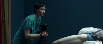 Movie still from “Hard Candy” (2005), directed by David Slade – A person holding a video camera in a room; Medium shot, Over the shoulder angle