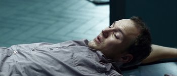 Movie still from “Hard Candy” (2005), directed by David Slade – A man laying on the ground with his eyes closed; Close Up shot, High angle