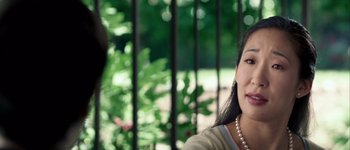 Movie still from “Hard Candy” (2005), directed by David Slade – A woman with a pearl necklace sitting in front of a fence; Close Up shot, Over the shoulder angle