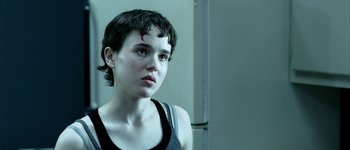 Movie still from “Hard Candy” (2005), directed by David Slade – A woman with short black hair is looking at the camera; Close Up shot, Over the shoulder angle