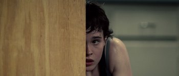 Movie still from “Hard Candy” (2005), directed by David Slade – A woman hiding her face behind a wooden wall; Close Up shot, Over the shoulder angle